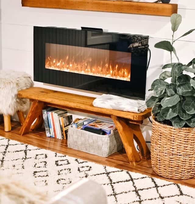 Cozy electric fireplace with modern wooden mantle in living room decor.