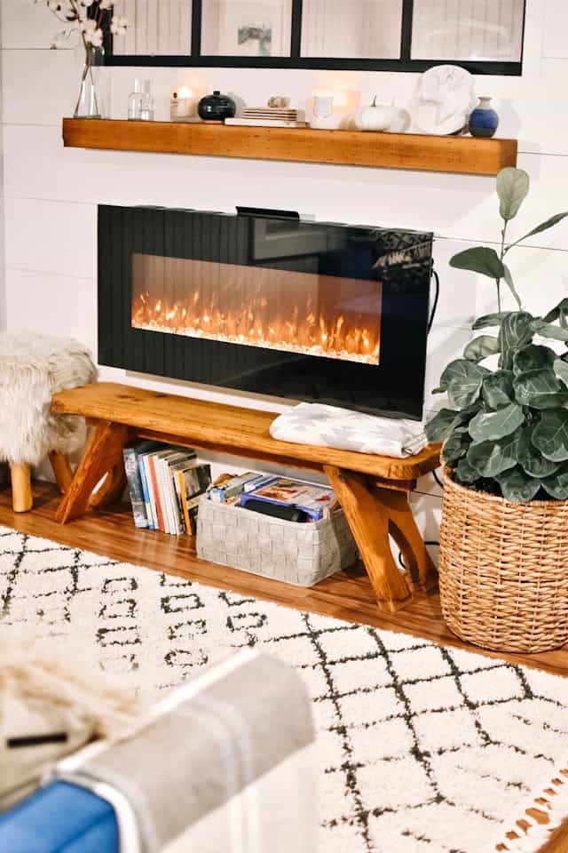 Cozy electric fireplace with modern wooden mantle in living room decor.